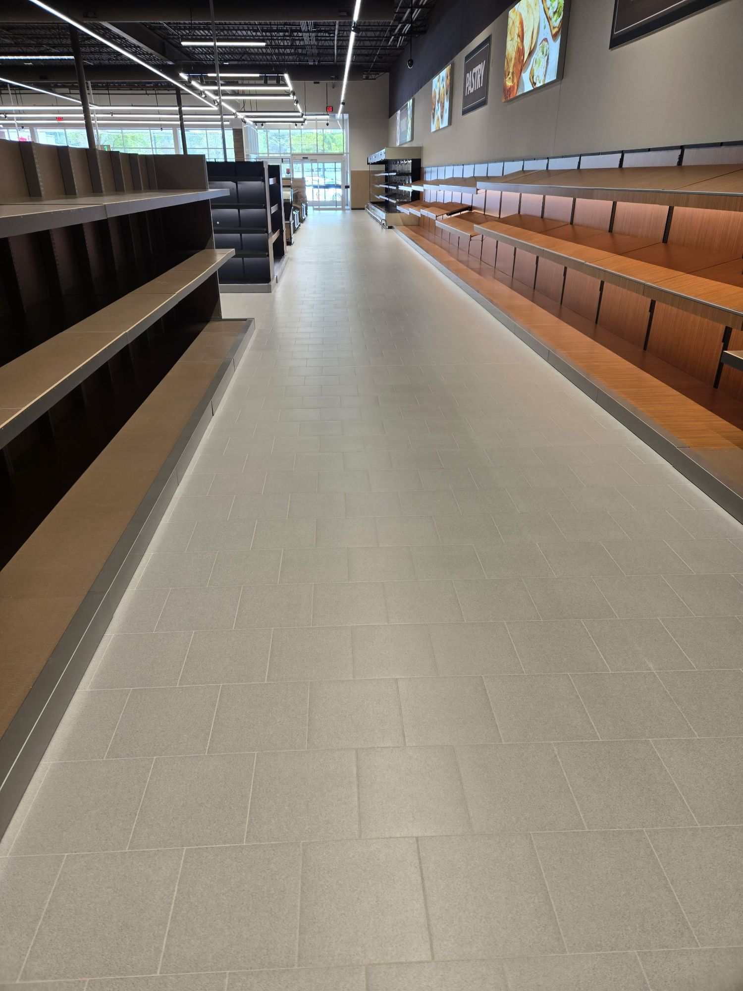 Grocery aisle with wood-trim shelving and a clean tile floor