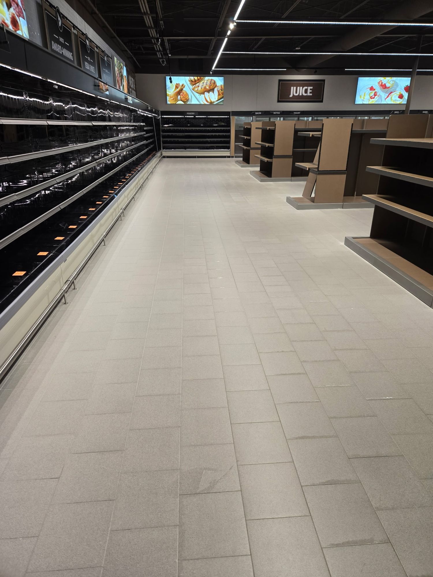 Perimeter grocery aisle with empty cases along the wall