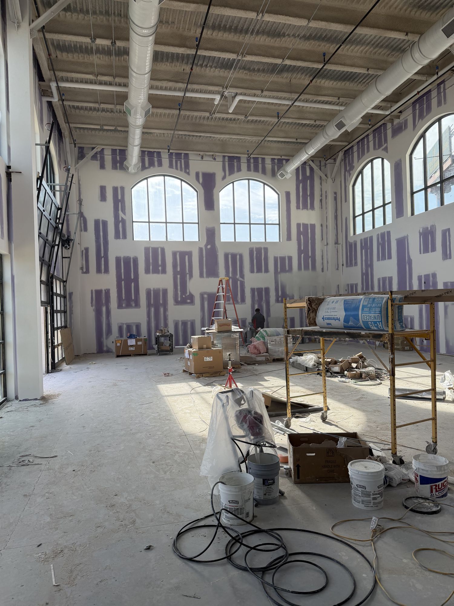 Interior under construction with materials and lifts on the floor