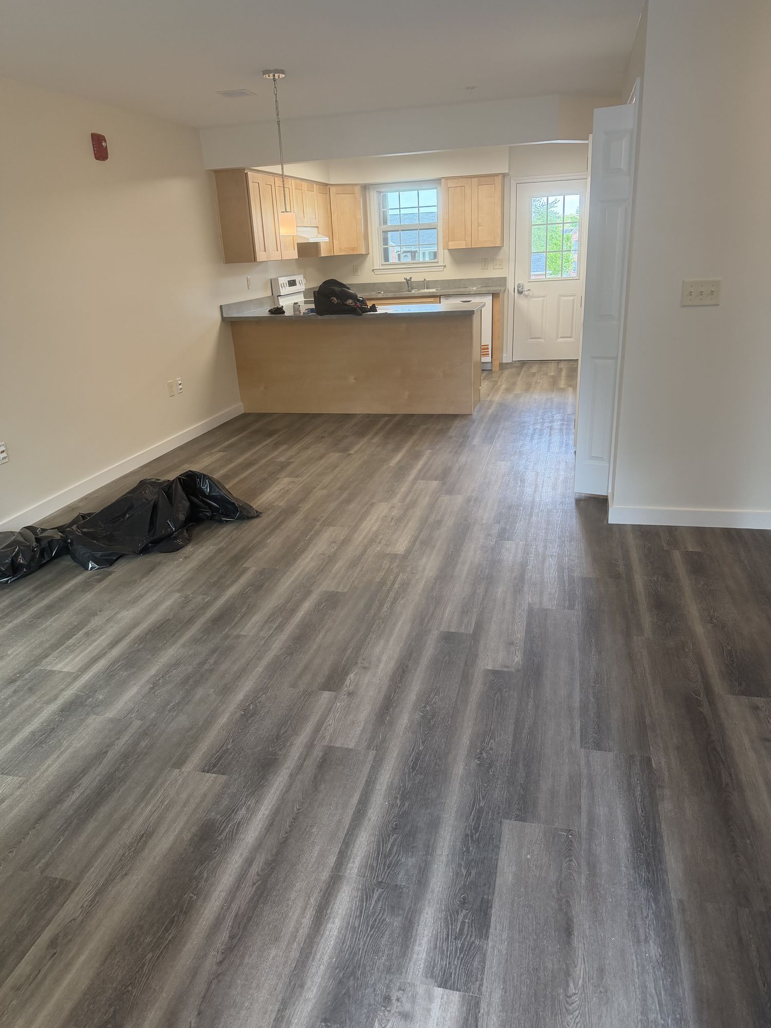Apartment unit mid-clean, plank floor and kitchen
